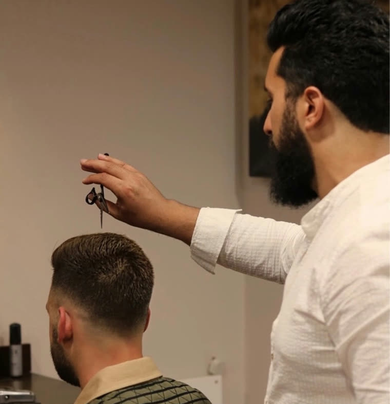 Barber working with scissors at Hams Of Richmond