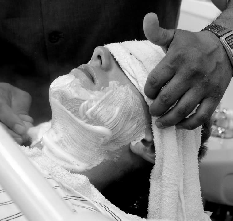 A hot towel shave in progress, lather and towels